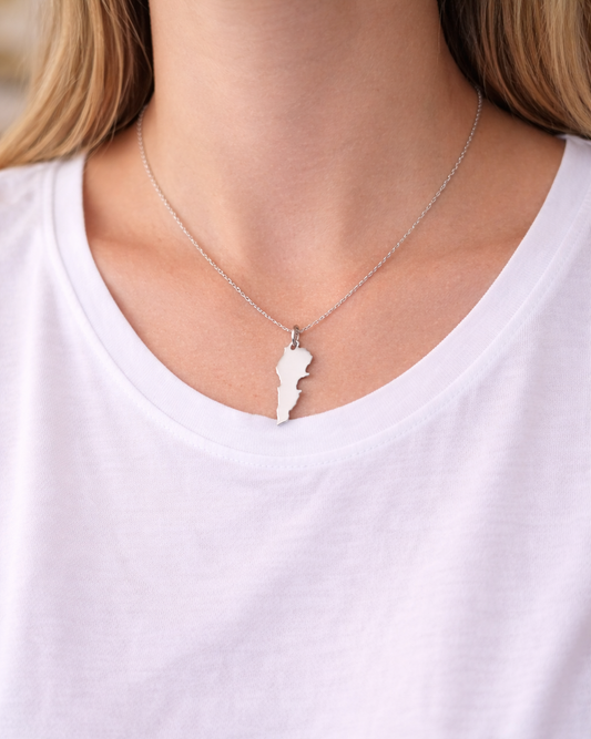 Necklace with a unique pendant worn by a person on a plain background