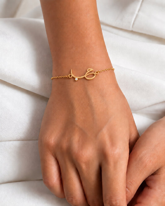Hob charm bracelet in a gold-plated finish, worn on the wrist