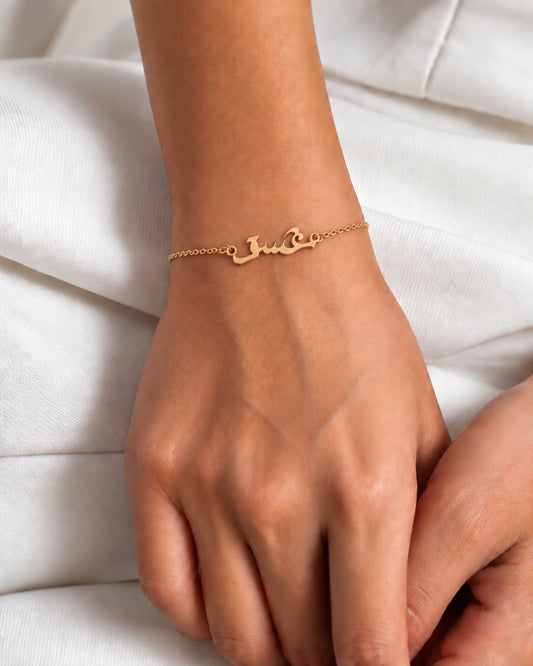 Gold-plated Ishq Arabic script bracelet worn on the wrist