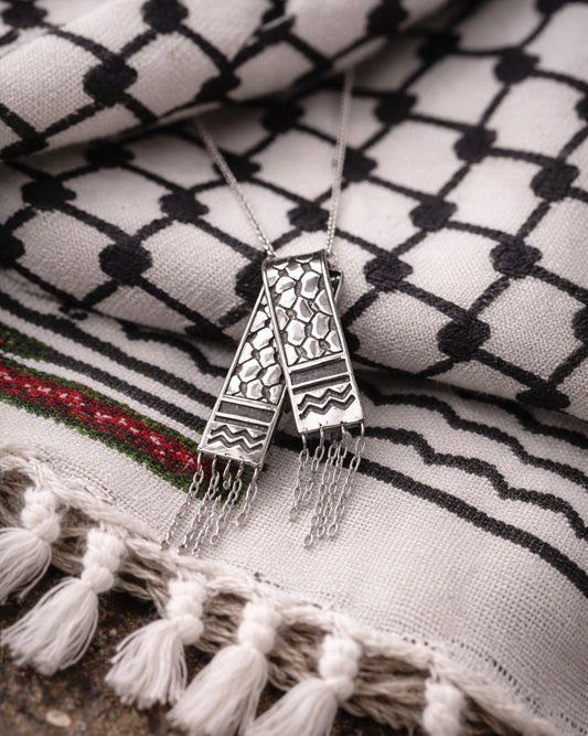 Decorative necklace with tassels on a patterned fabric background