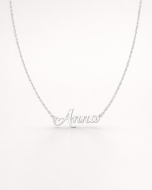 Silver necklace with 'Amira' pendant on a white background