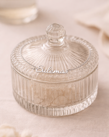 Clear glass trinket dish with lid on a soft beige background