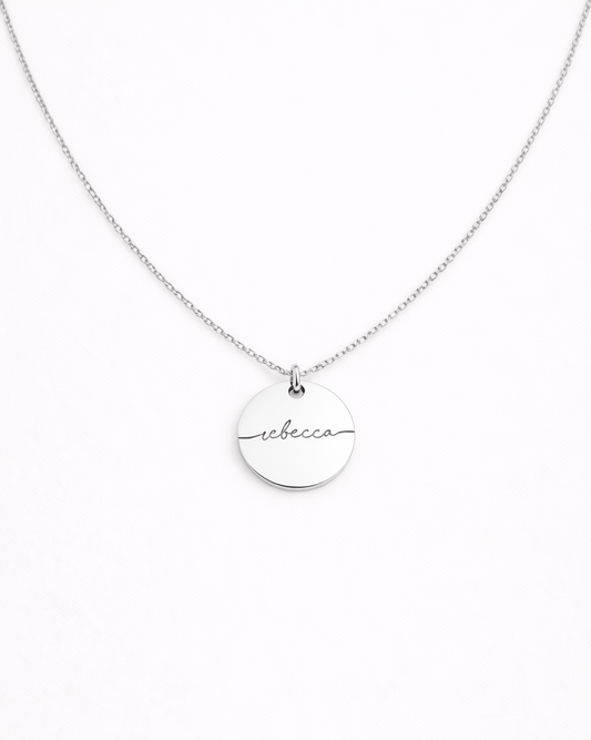 Silver necklace with a round pendant on a white background