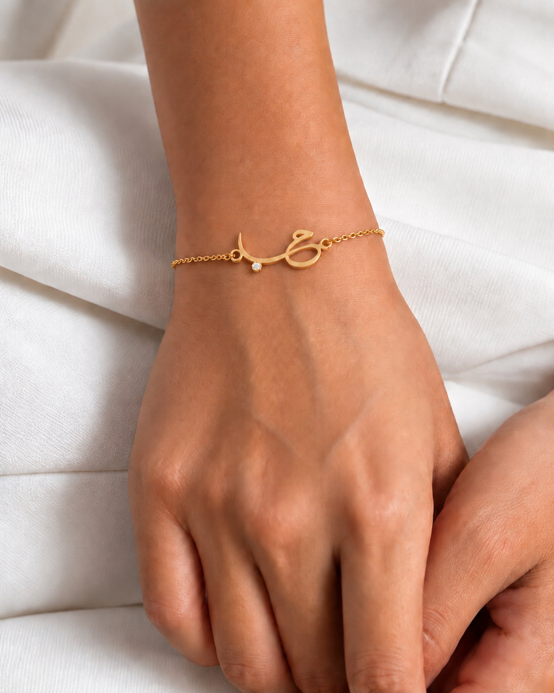 Hob charm bracelet in a gold-plated finish, worn on the wrist