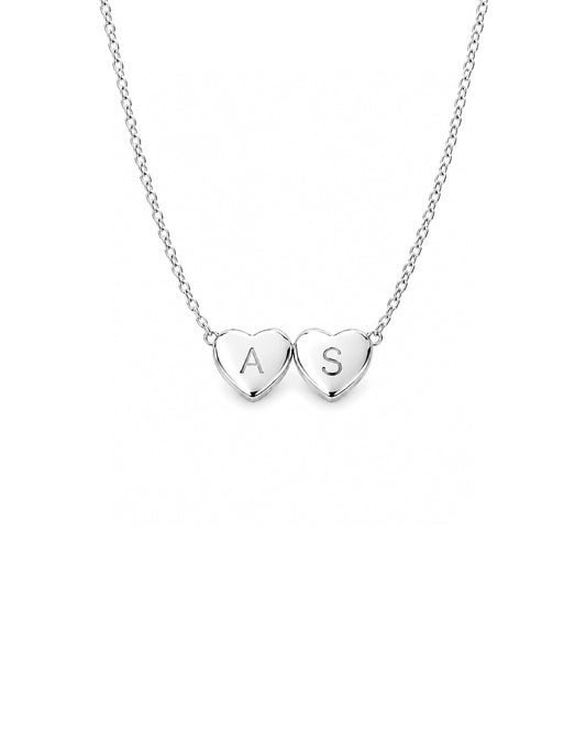 Silver necklace with two heart-shaped pendants on a white background
