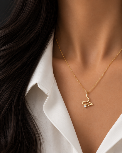 Gold-plated Hubb Arabic script necklace with a cubic zirconia stone worn at the collarbone