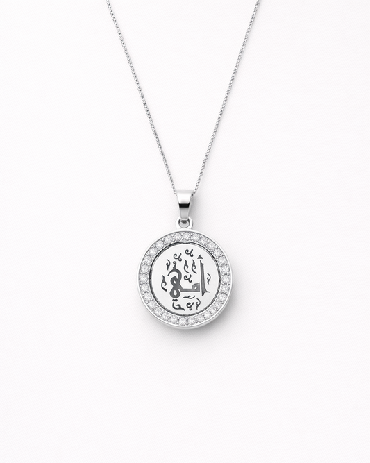 Silver necklace with a round pendant on a white background