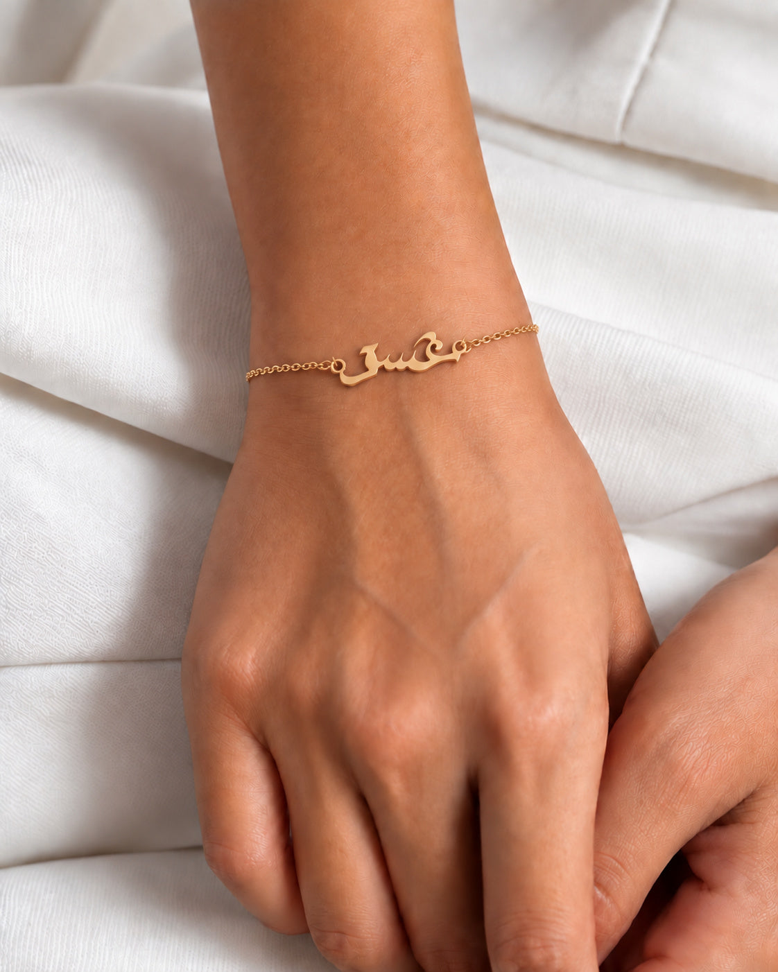 Gold-plated Ishq Arabic script bracelet worn on the wrist
