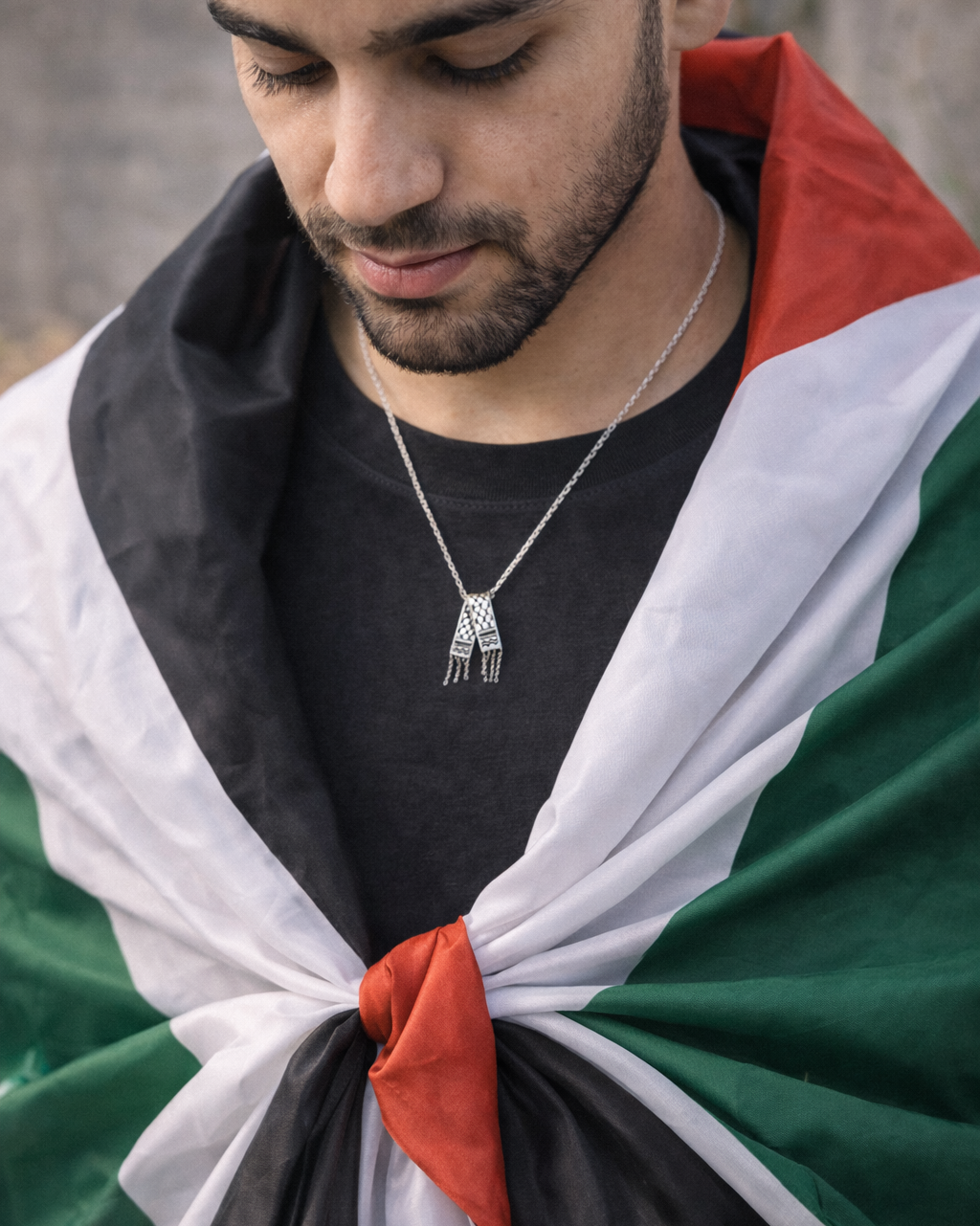Man wearing a flag draped over his shoulders with a neutral background