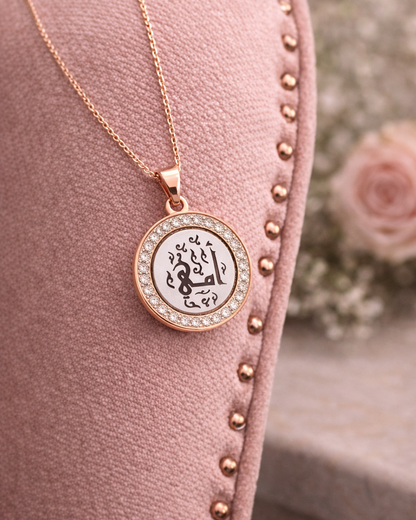 Rose gold necklace with a round pendant on a pink cushion with floral background