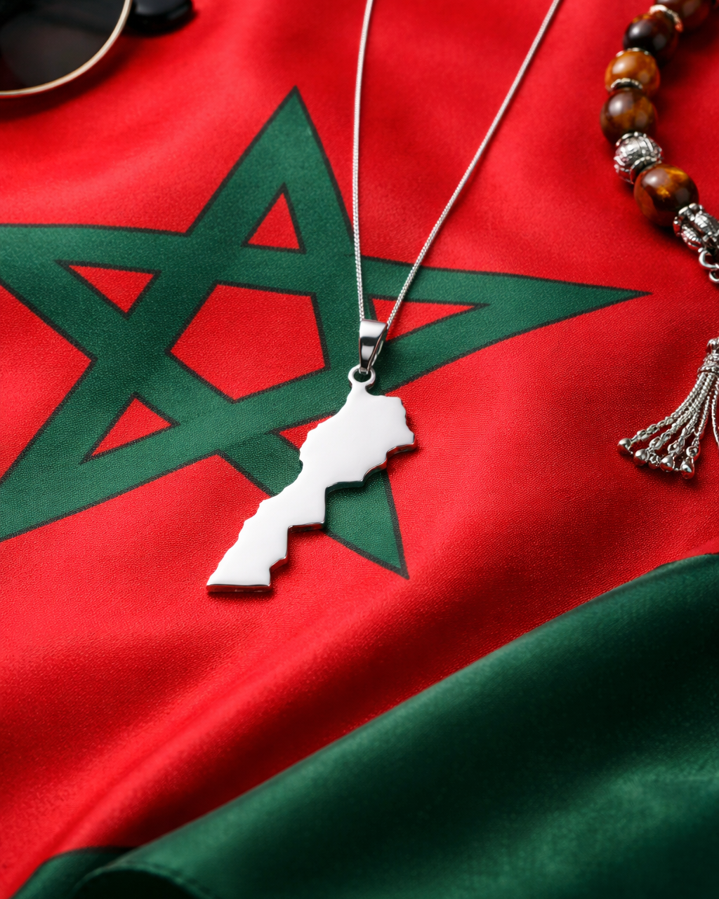 Silver necklace with a pendant on a red and green fabric background